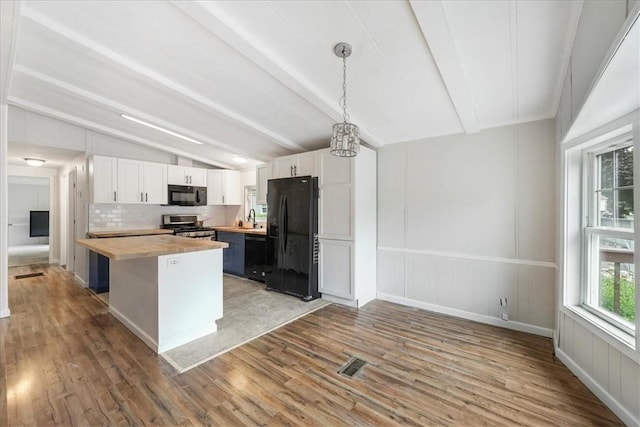 kitchen featuring wood counters, black appliances, light hardwood / wood-style flooring, white cabinetry, and hanging light fixtures