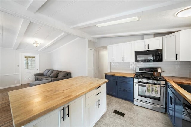 kitchen with butcher block counters, stainless steel gas range, lofted ceiling with beams, decorative backsplash, and white cabinets