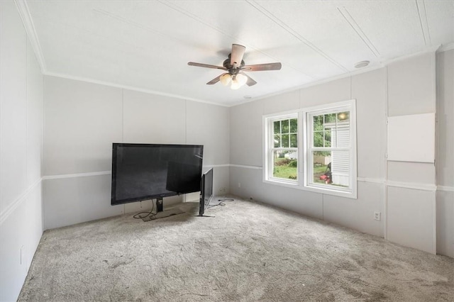 unfurnished living room featuring carpet floors, ceiling fan, and ornamental molding