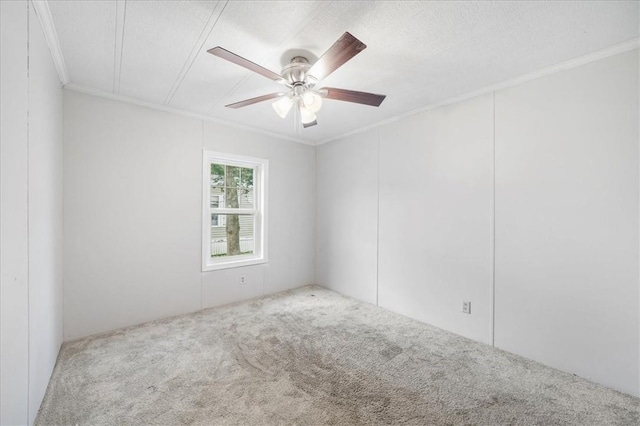 carpeted empty room featuring ceiling fan, ornamental molding, and a textured ceiling