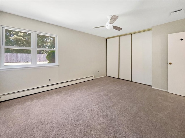 unfurnished bedroom featuring carpet flooring, a closet, ceiling fan, and a baseboard heating unit