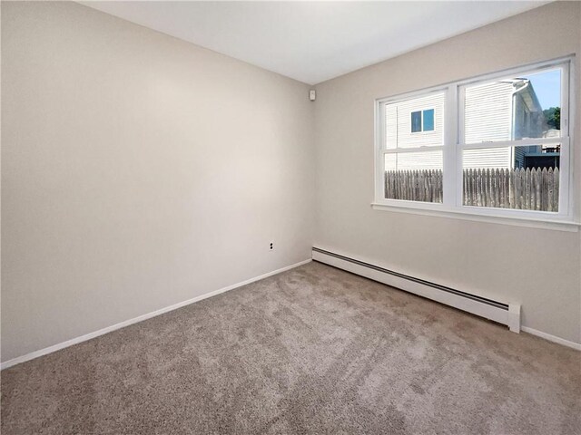 carpeted spare room featuring a baseboard radiator