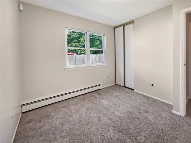 empty room featuring carpet and a baseboard radiator