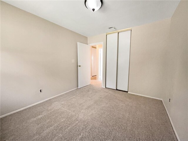 unfurnished bedroom featuring carpet flooring and a closet
