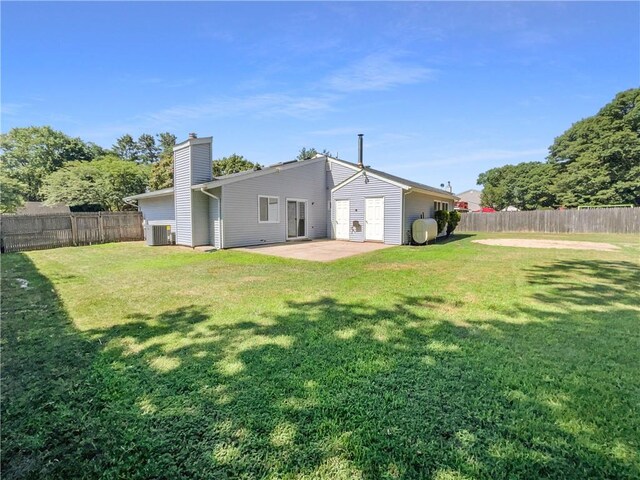 back of house featuring a yard, central AC unit, and a patio area