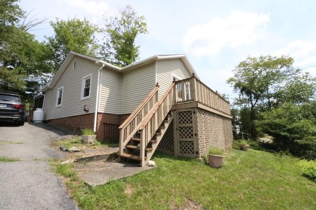 view of home's exterior with a lawn and a wooden deck