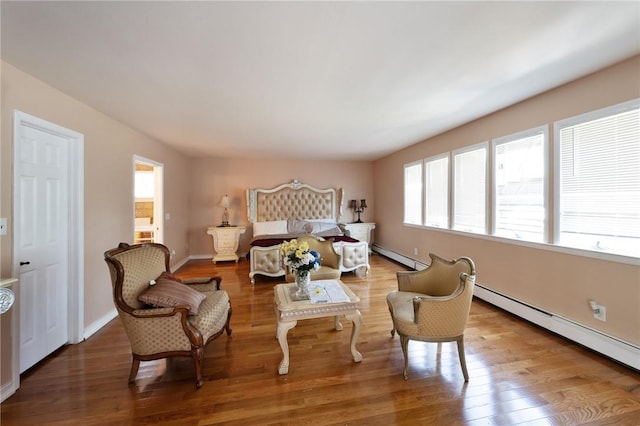 bedroom with baseboards, baseboard heating, and wood finished floors