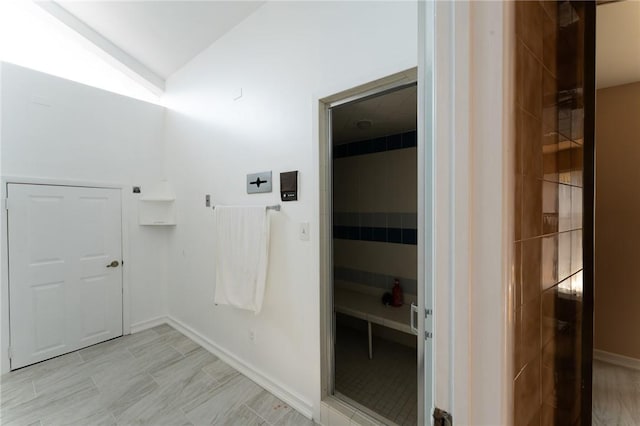 interior space featuring lofted ceiling and baseboards