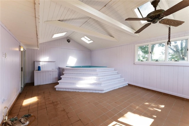 interior space with vaulted ceiling with skylight and tile patterned floors