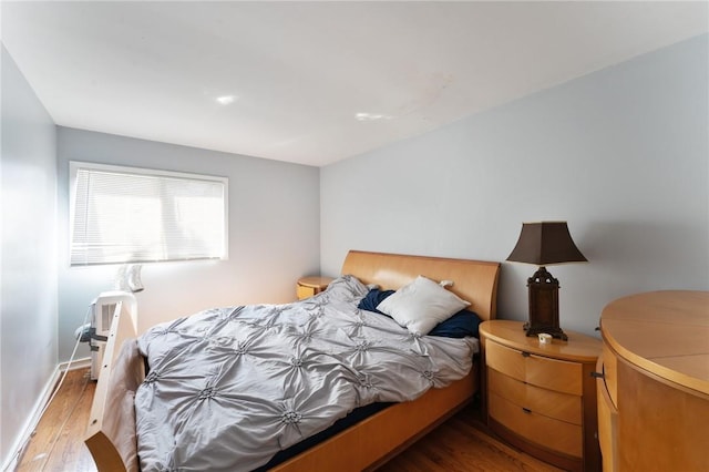 bedroom with baseboards and wood finished floors