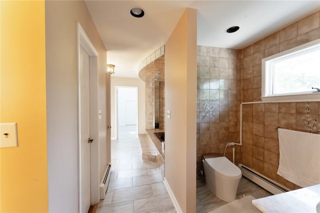 full bathroom with a baseboard heating unit, toilet, decorative columns, and tile walls