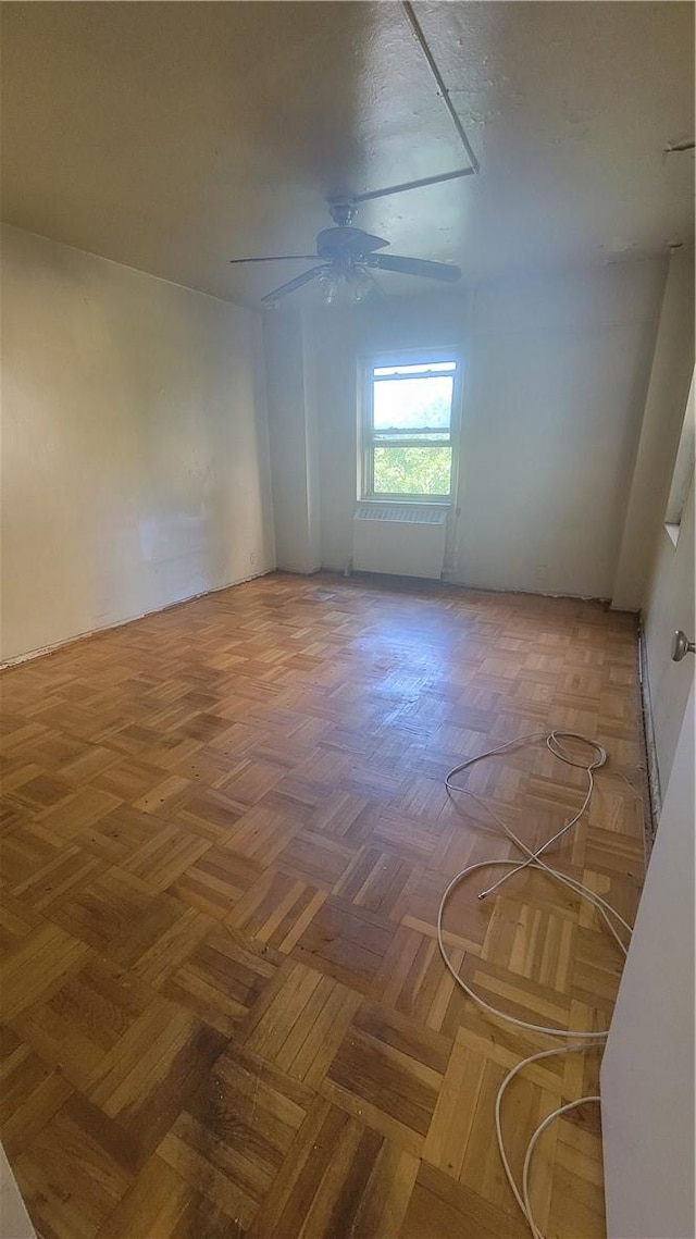 unfurnished room featuring ceiling fan and parquet flooring