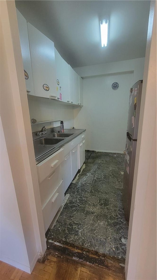 kitchen featuring stainless steel fridge, sink, white cabinets, and dark wood-type flooring