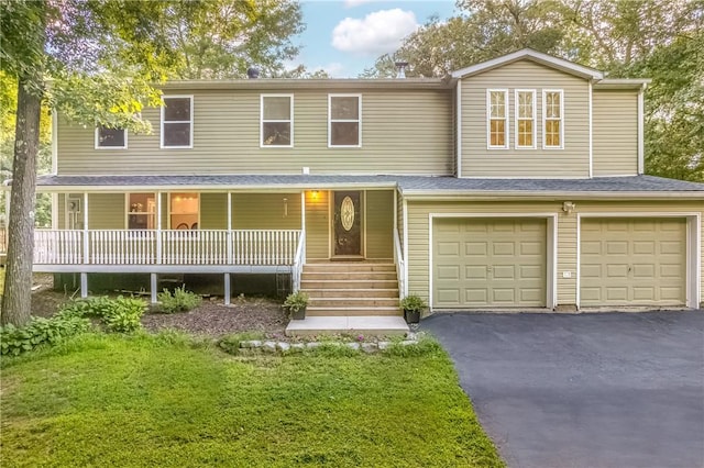 view of front of home featuring a porch, a garage, and a front lawn