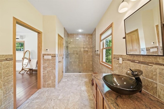 bathroom featuring vanity, tile walls, a wainscoted wall, a stall shower, and a wall mounted air conditioner