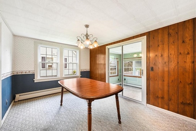 office area with a healthy amount of sunlight, baseboard heating, wooden walls, and an inviting chandelier