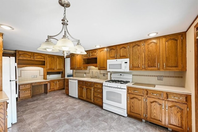 kitchen featuring pendant lighting, white appliances, tasteful backsplash, and sink