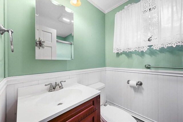 bathroom featuring crown molding, vanity, and toilet