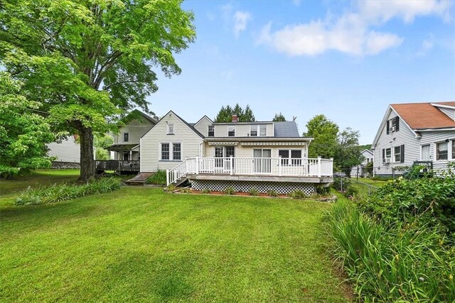 rear view of house with a yard and a deck