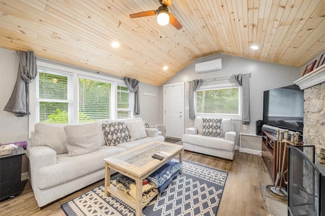 living room featuring hardwood / wood-style floors, vaulted ceiling, a wealth of natural light, and a wall unit AC