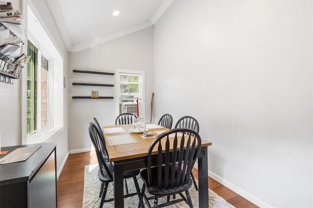 dining area featuring wood-type flooring, vaulted ceiling, and ornamental molding