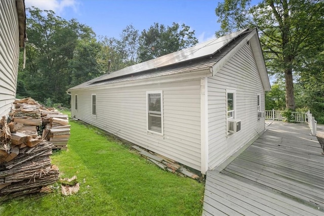 view of property exterior with solar panels, a yard, and a wooden deck