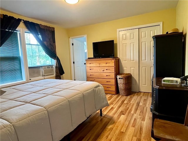 bedroom featuring a closet, cooling unit, and light wood-type flooring