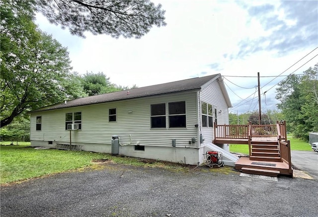 back of house featuring a wooden deck and a yard