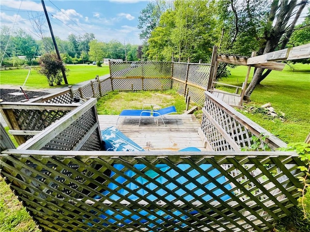 view of pool with a lawn and a deck