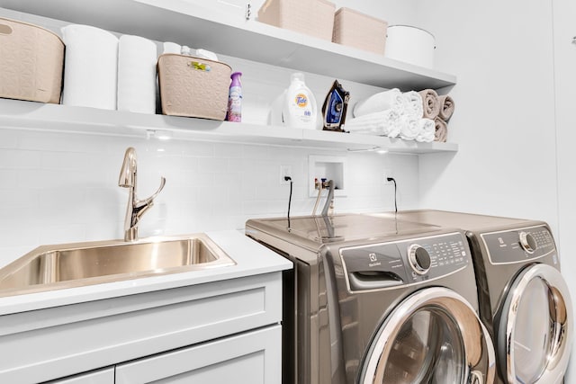 laundry area with sink and washing machine and clothes dryer