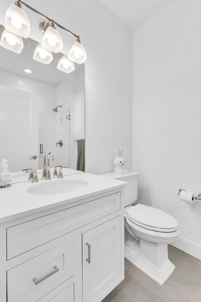 bathroom with walk in shower, vanity, and toilet