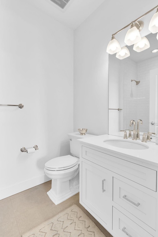 bathroom featuring vanity, tiled shower, tile patterned floors, and toilet