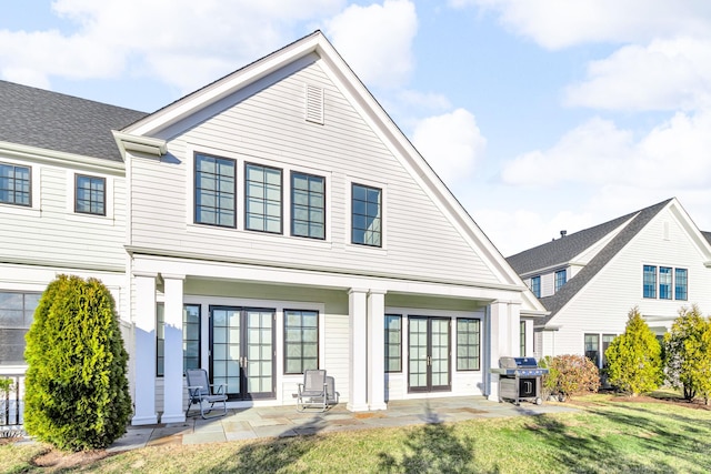 back of property with french doors, a yard, and a patio area