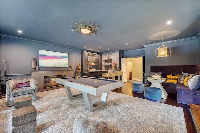 playroom with billiards, a tiled fireplace, ornamental molding, and hardwood / wood-style flooring