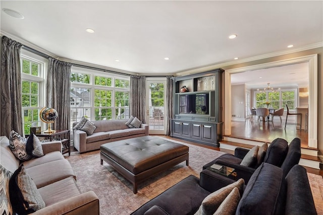 living room featuring a wealth of natural light, crown molding, and light hardwood / wood-style flooring