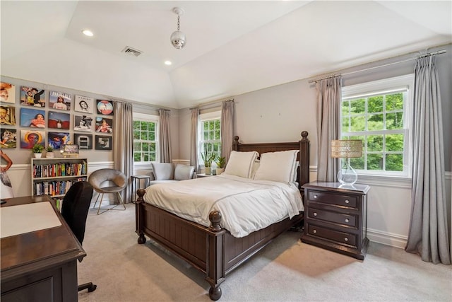 bedroom featuring light carpet, a tray ceiling, and multiple windows