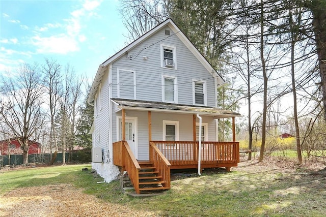 back of property with covered porch and a yard