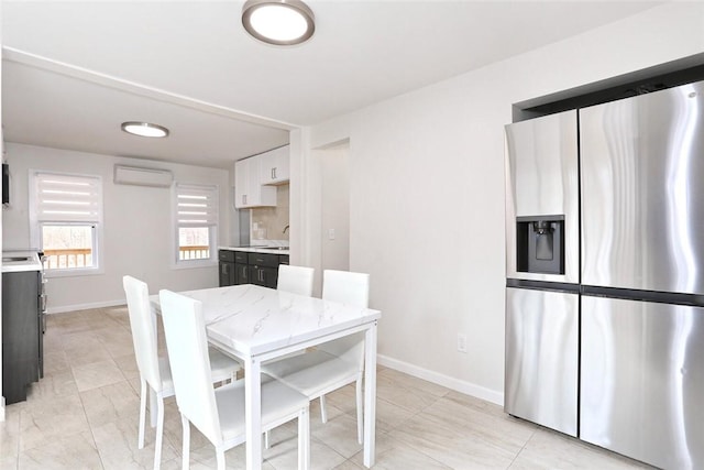 dining area with an AC wall unit and sink