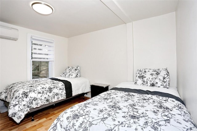 bedroom featuring wood-type flooring and a wall unit AC