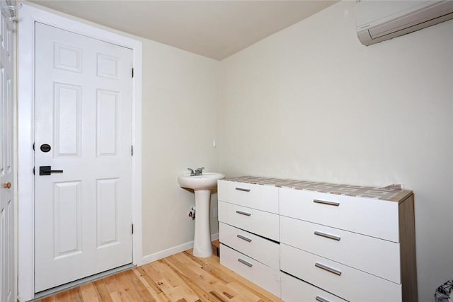 bathroom with an AC wall unit and hardwood / wood-style floors