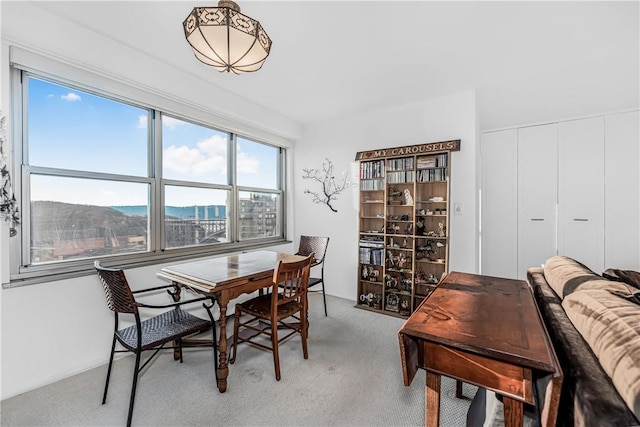 dining room with a mountain view and light colored carpet