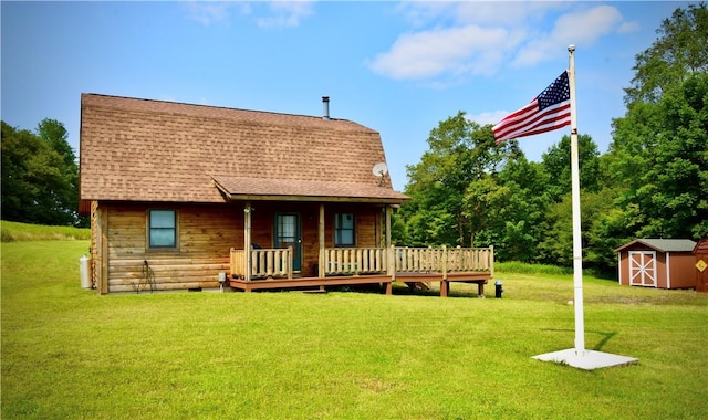 back of property with a shed, a wooden deck, and a lawn