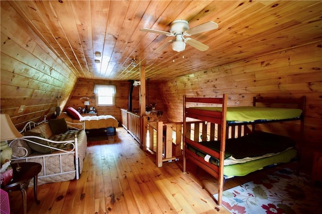 bedroom with hardwood / wood-style floors, wood walls, lofted ceiling, and wooden ceiling