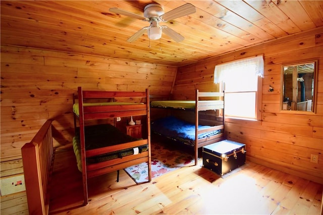 bedroom featuring wood walls and light hardwood / wood-style flooring