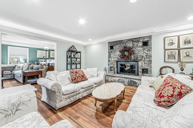 living room with a fireplace, hardwood / wood-style flooring, and crown molding