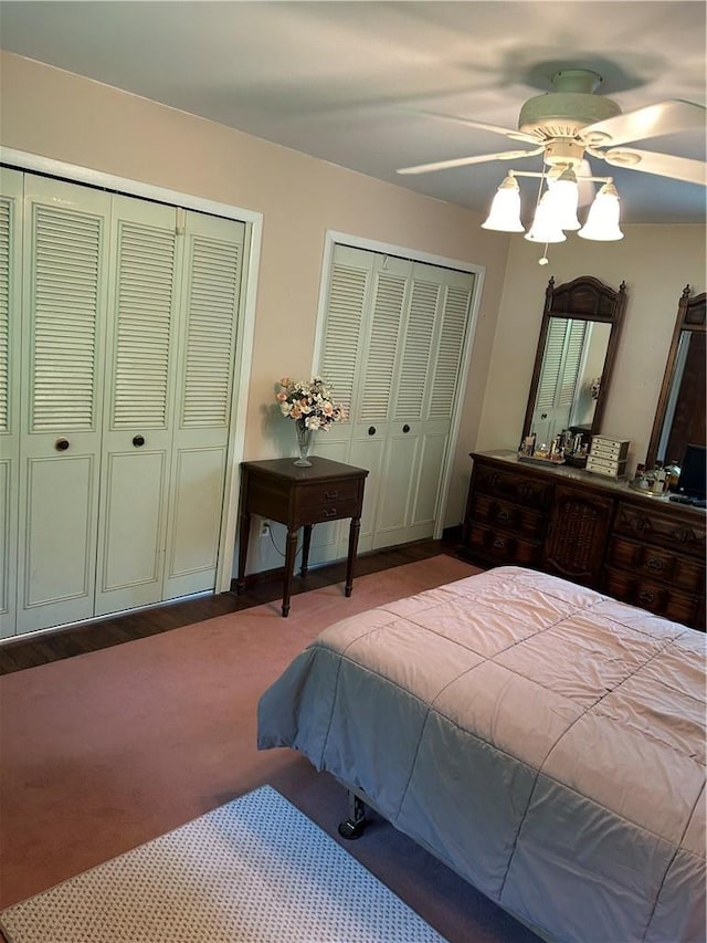 carpeted bedroom featuring ceiling fan and multiple closets