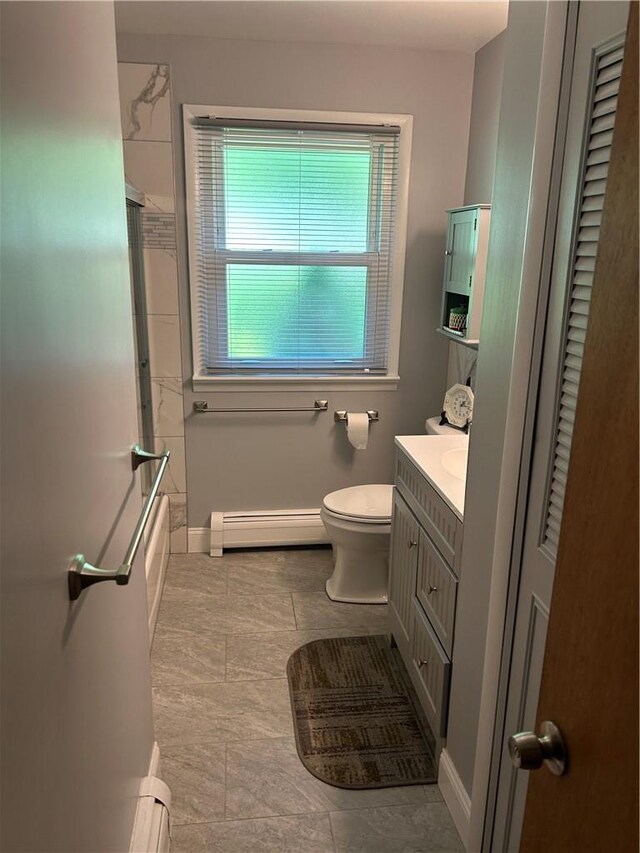 full bathroom featuring shower / bath combination with glass door, vanity, a baseboard radiator, and toilet