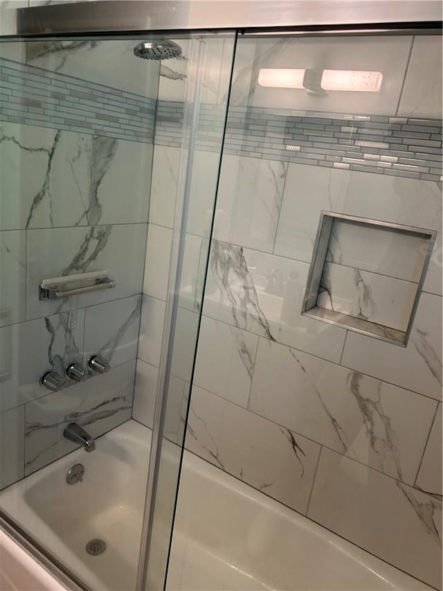 bathroom featuring bath / shower combo with glass door