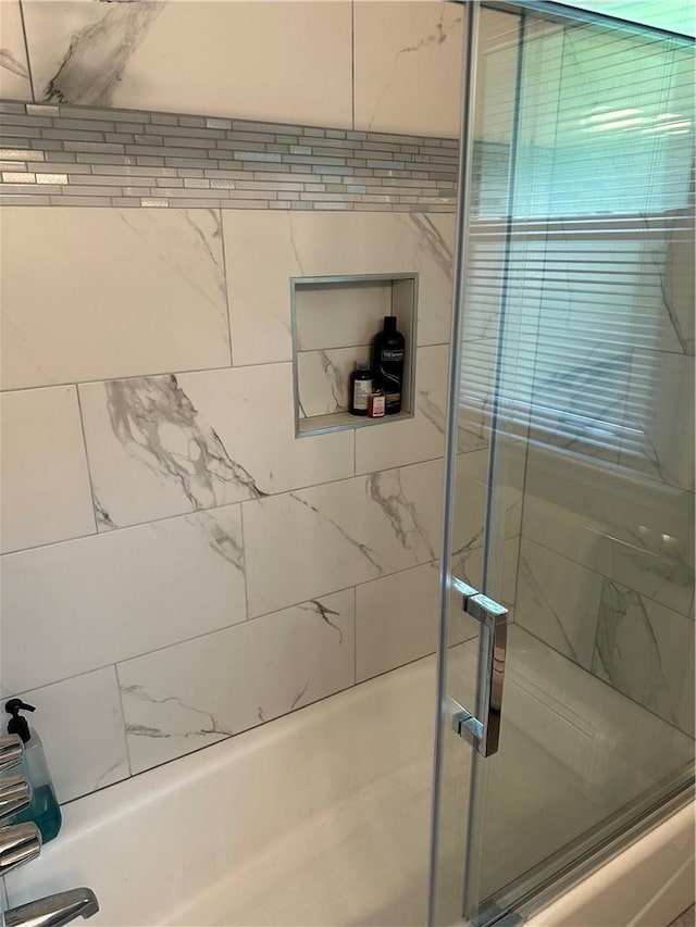 details with shower / bath combination with glass door