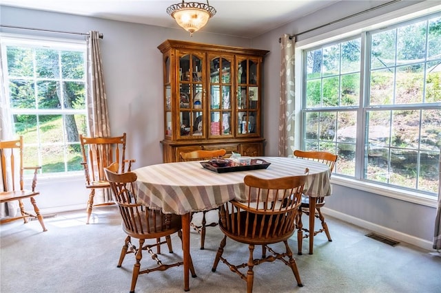 carpeted dining area featuring plenty of natural light